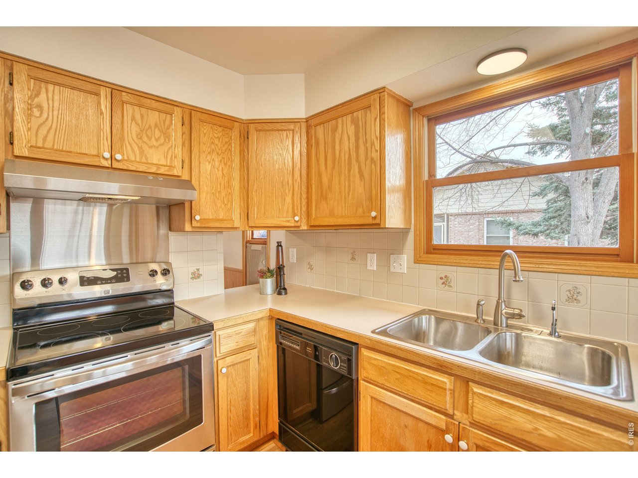 824 Wade Road Longmont, CO 80503 - Photo 11 of 34 a kitchen with stainless steel appliances a sink a stove and white cabinets