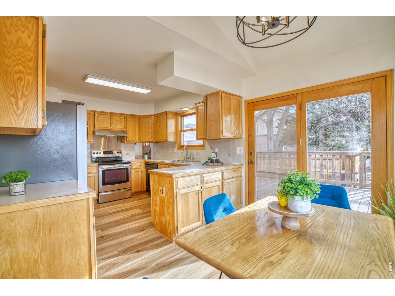 824 Wade Road Longmont, CO 80503 - Photo 14 of 34 a kitchen with kitchen island a stove a sink a dining table and chairs