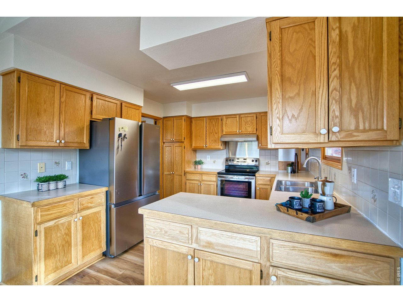 824 Wade Road Longmont, CO 80503 - Photo 9 of 34 a kitchen with a refrigerator and a stove top oven