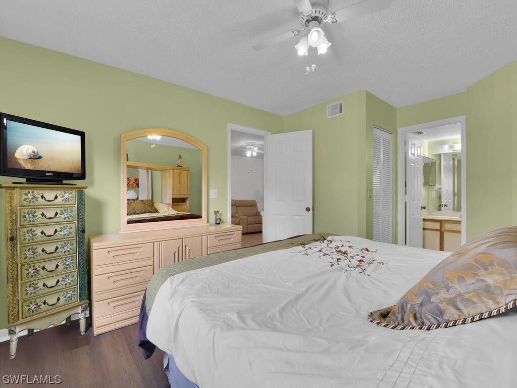 654 Squire Circle, Unit 103 Naples, FL 34104 - Photo 14 of 23 a spacious bedroom with a bed and a flat screen tv