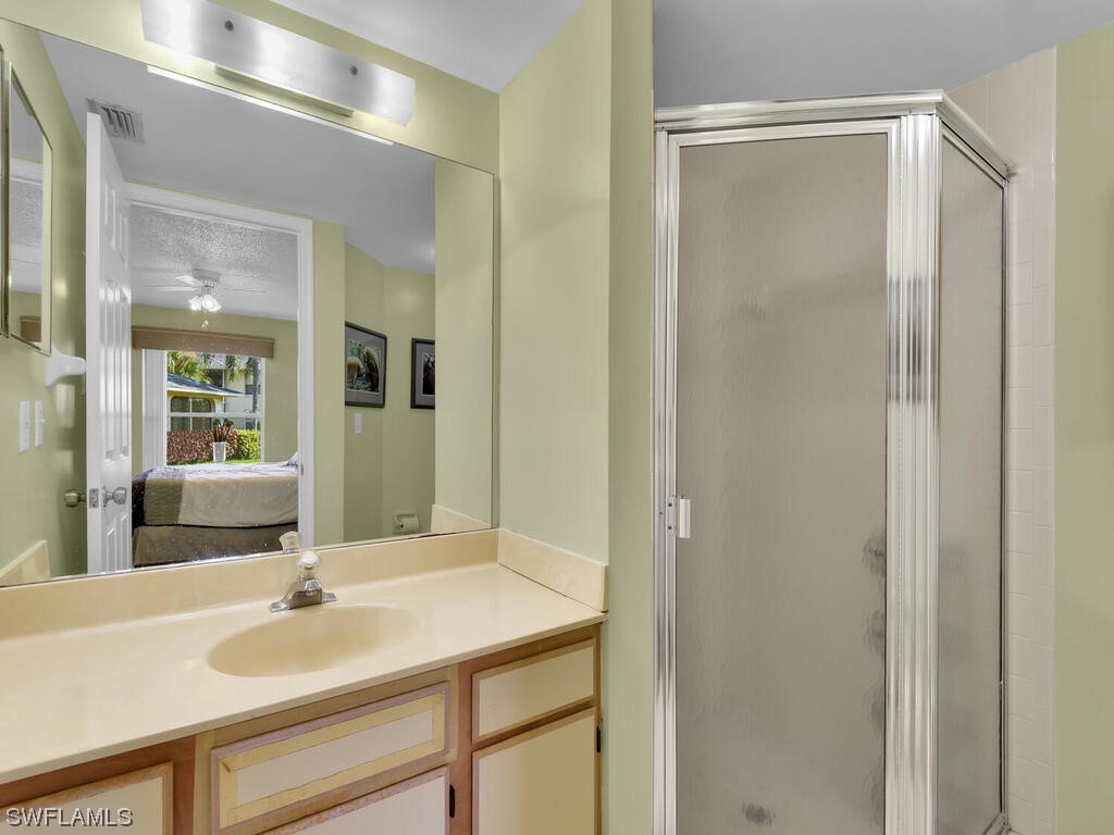 654 Squire Circle, Unit 103 Naples, FL 34104 - Photo 15 of 23 a bathroom with a sink and a mirror