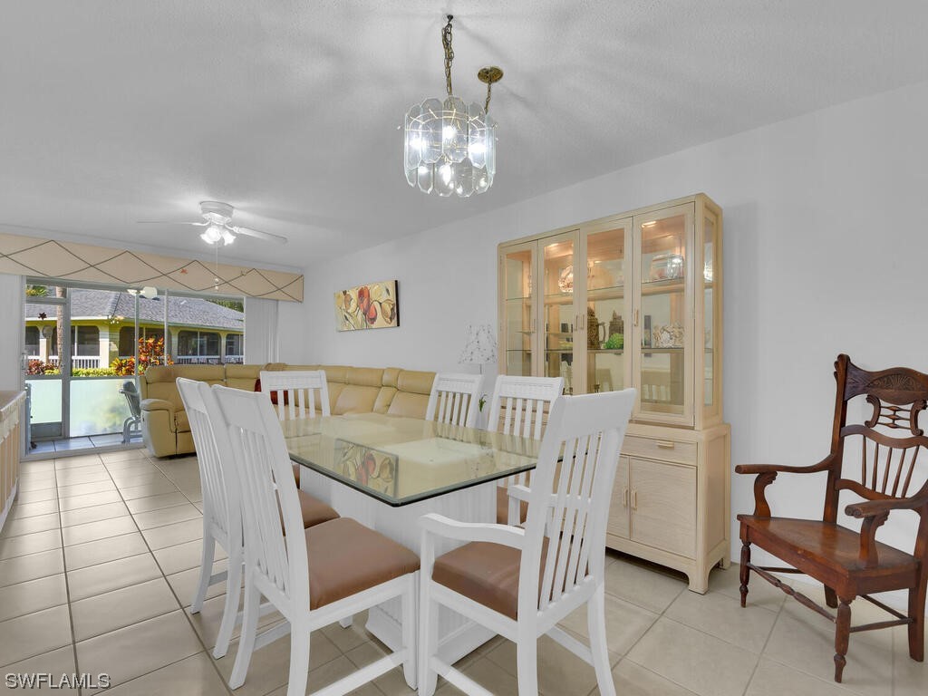 654 Squire Circle, Unit 103 Naples, FL 34104 - Photo 2 of 23 a dining room with furniture a chandelier and window