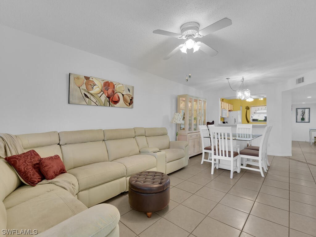 654 Squire Circle, Unit 103 Naples, FL 34104 - Photo 3 of 23 a living room with furniture and a chandelier