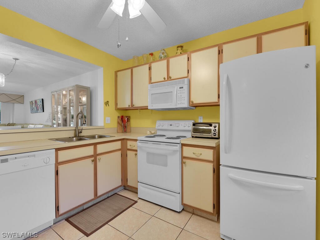 654 Squire Circle, Unit 103 Naples, FL 34104 - Photo 7 of 23 a kitchen with appliances cabinets and a sink