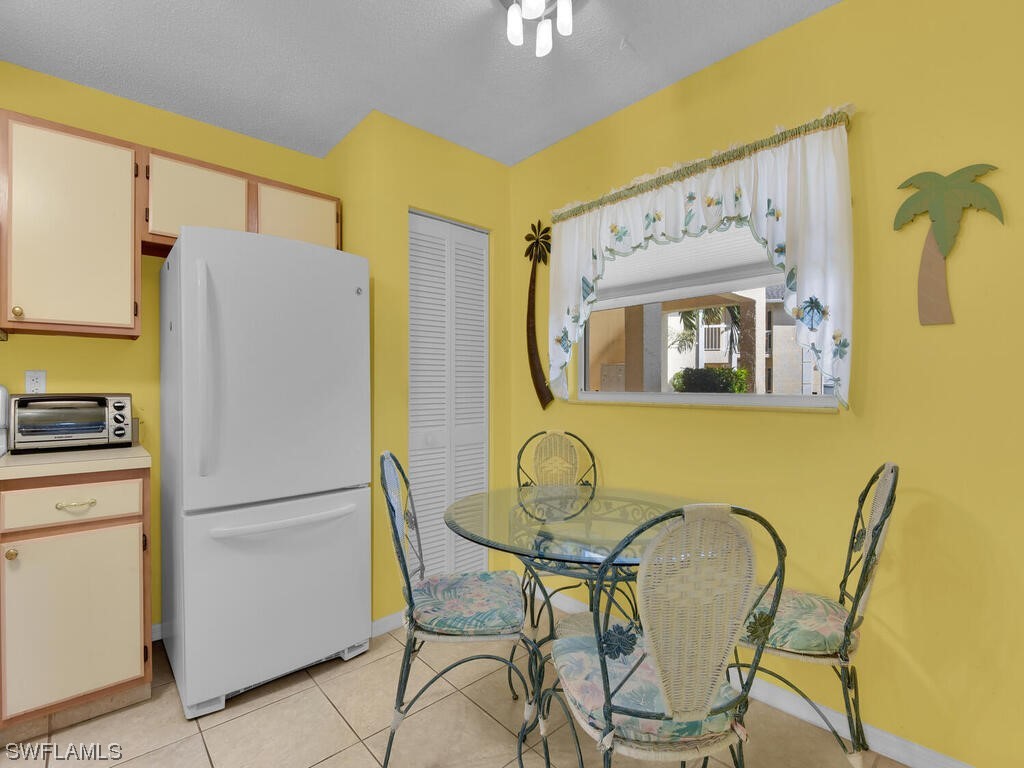 654 Squire Circle, Unit 103 Naples, FL 34104 - Photo 8 of 23 a white kitchen with a refrigerator and furniture