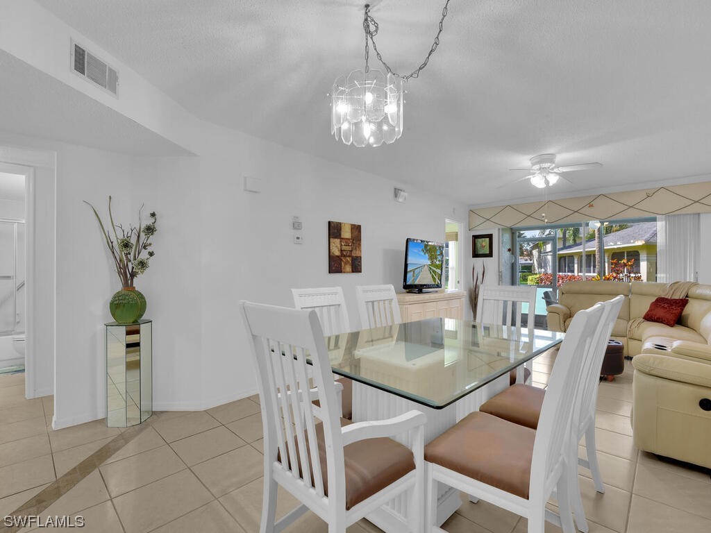654 Squire Circle, Unit 103 Naples, FL 34104 - Photo 10 of 23 a view of a dining room with furniture and chandelier