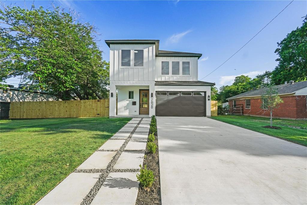 a front view of a house with a garden and trees