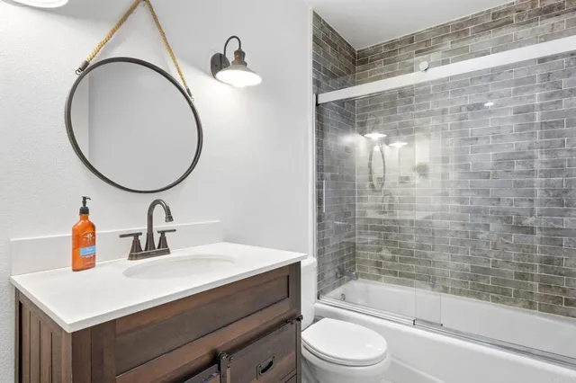 a bathroom with a sink a toilet and a mirror