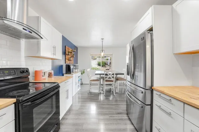 a kitchen with granite countertop a stove a sink and a refrigerator