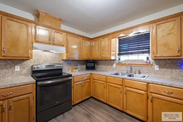 a kitchen with stainless steel appliances granite countertop a sink stove and cabinets