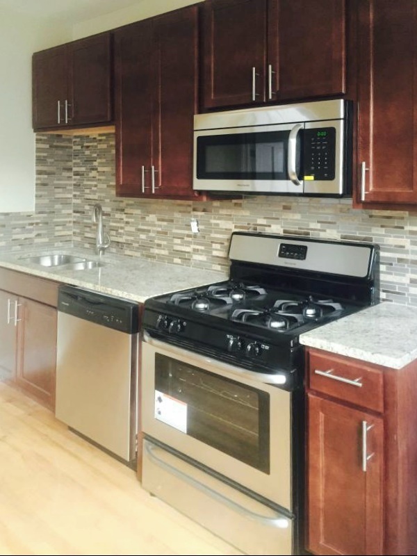 4815 North Springfield Avenue, Unit 3E Chicago, IL 60625 - Photo 2 of 8 a kitchen with stainless steel appliances granite countertop a stove microwave and cabinets