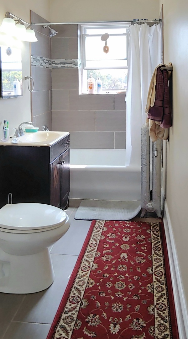 4815 North Springfield Avenue, Unit 3E Chicago, IL 60625 - Photo 4 of 8 a bathroom with a toilet a sink and mirror
