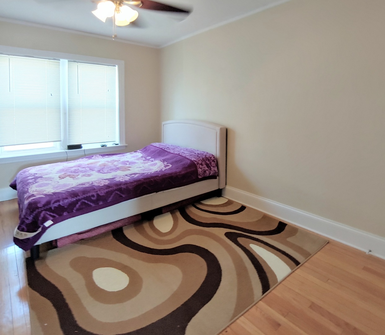 4815 North Springfield Avenue, Unit 3E Chicago, IL 60625 - Photo 5 of 8 a bedroom with a bed and a chandelier