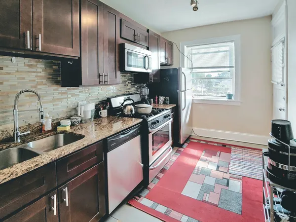 a kitchen with stainless steel appliances granite countertop a sink stove and refrigerator