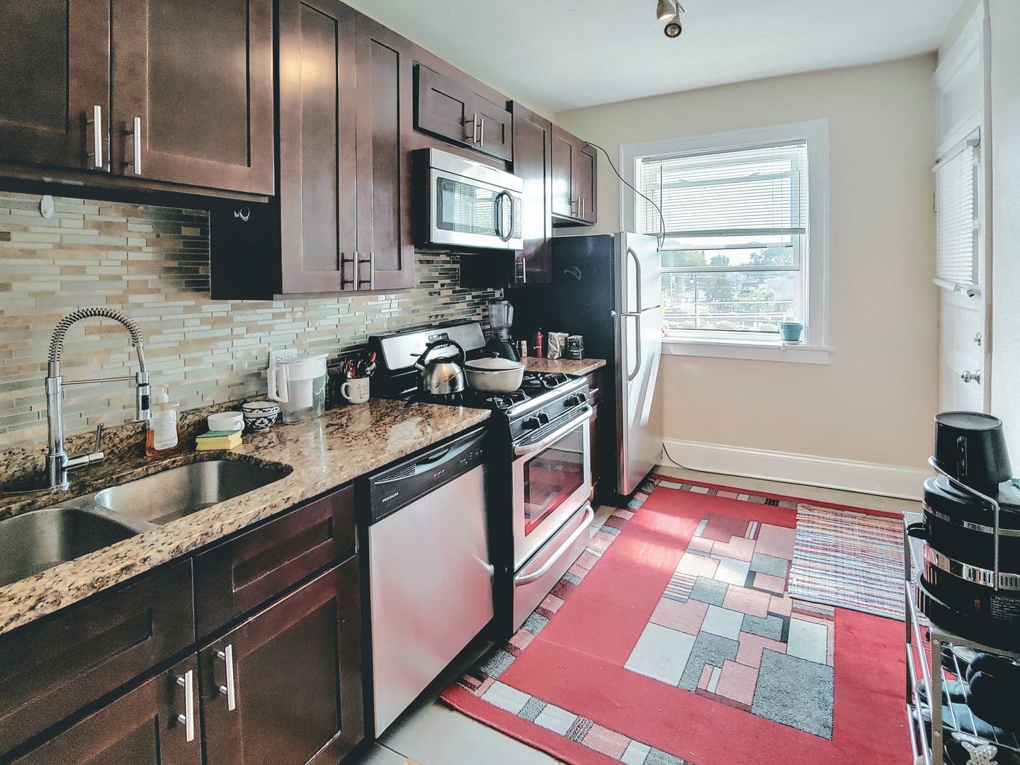4815 North Springfield Avenue, Unit 3E Chicago, IL 60625 - Photo 8 of 8 a kitchen with stainless steel appliances granite countertop a sink stove and refrigerator