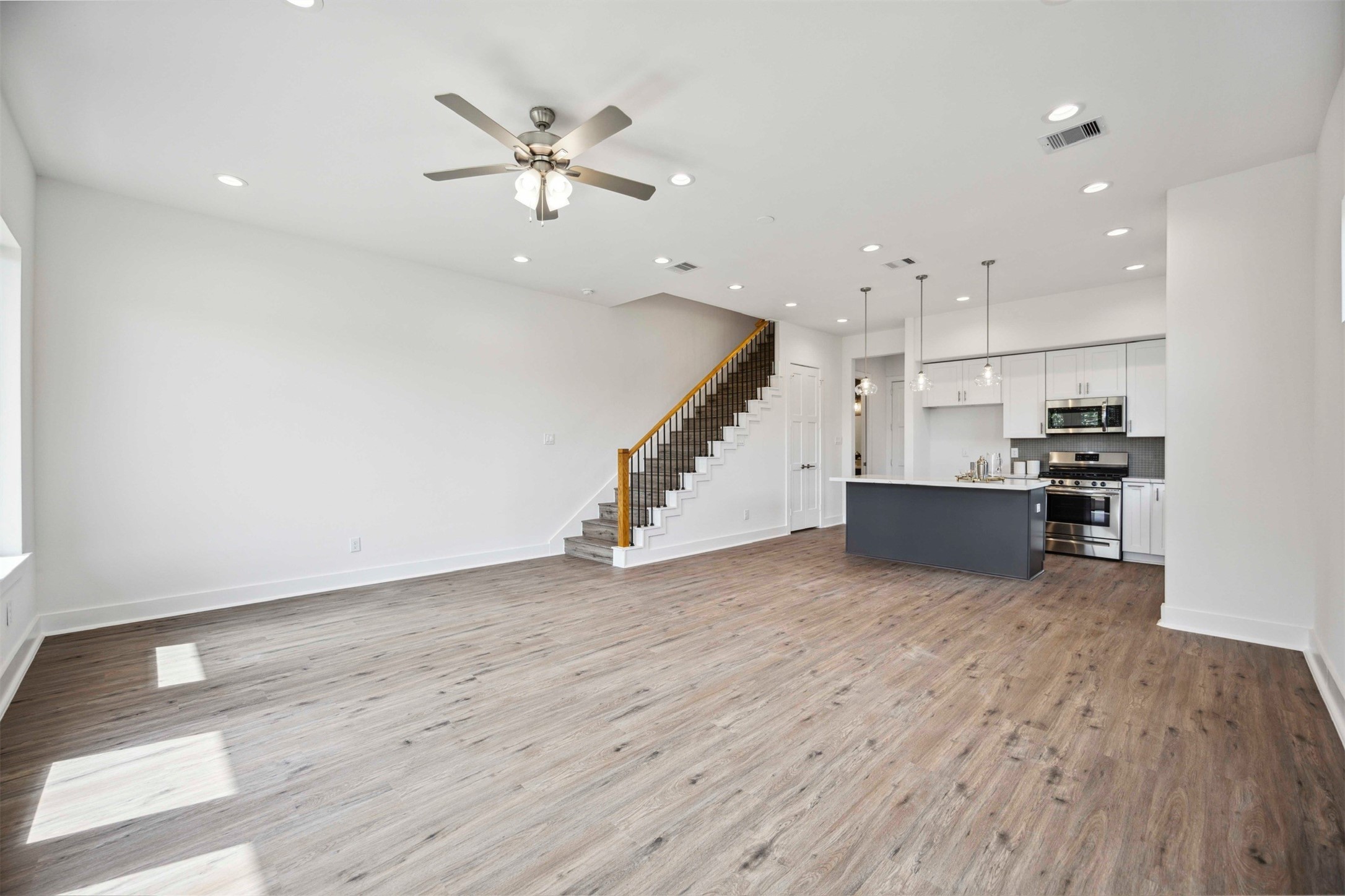 3504 Caplin Street, Unit B Houston, TX 77026 - Photo 8 of 26 a view of an empty room with wooden floor and a ceiling fan