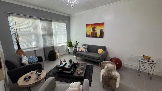 a living room with furniture a fireplace and a chandelier