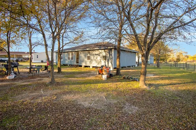 a backyard of a house with table and chairs