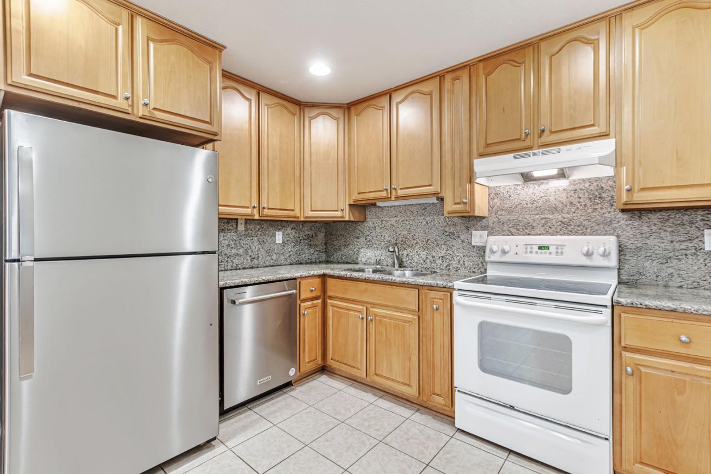 49 Showers Drive, Unit W203 Mountain View, CA 94040 - Photo 21 of 38 a kitchen with stainless steel appliances granite countertop a refrigerator sink and cabinets