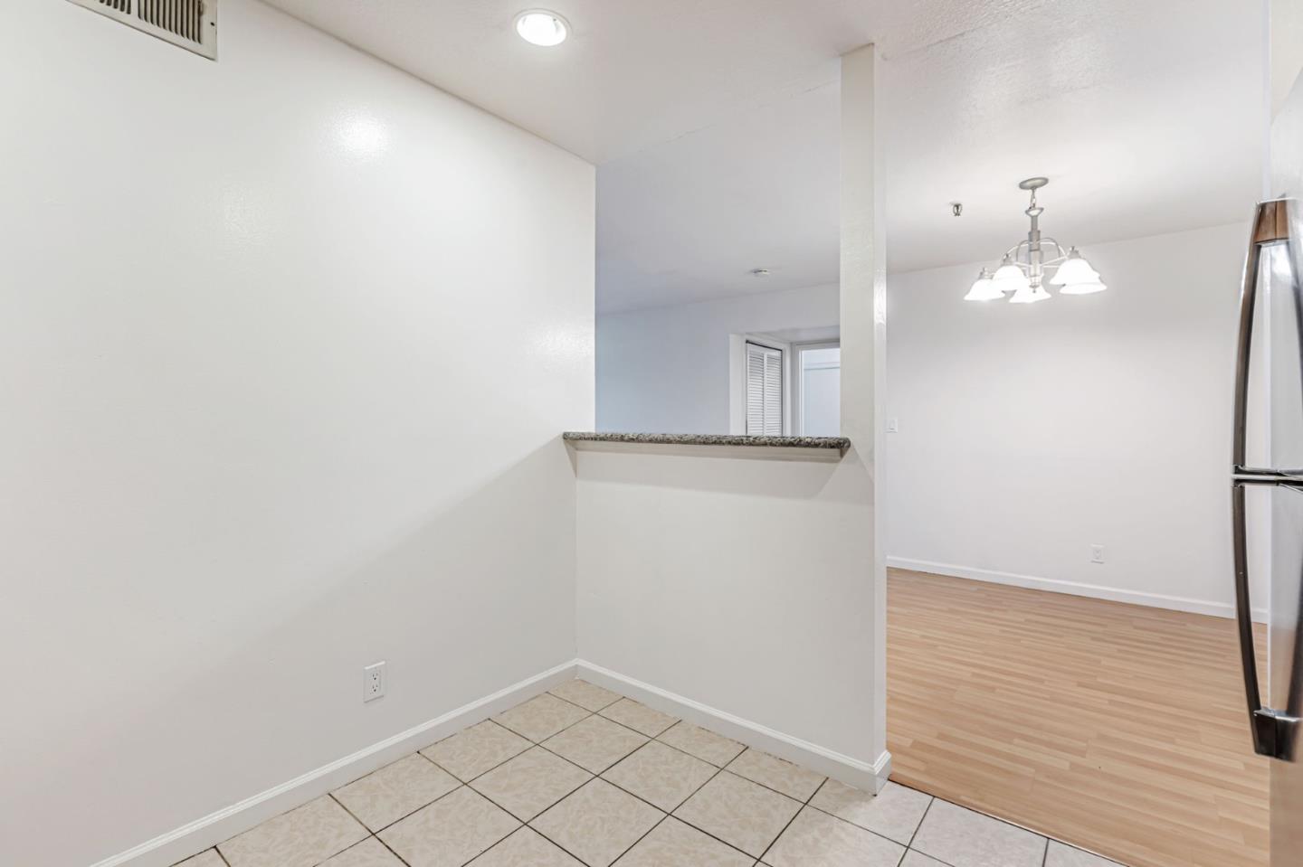 49 Showers Drive, Unit W203 Mountain View, CA 94040 - Photo 24 of 38 an empty room with wooden floor and chandelier