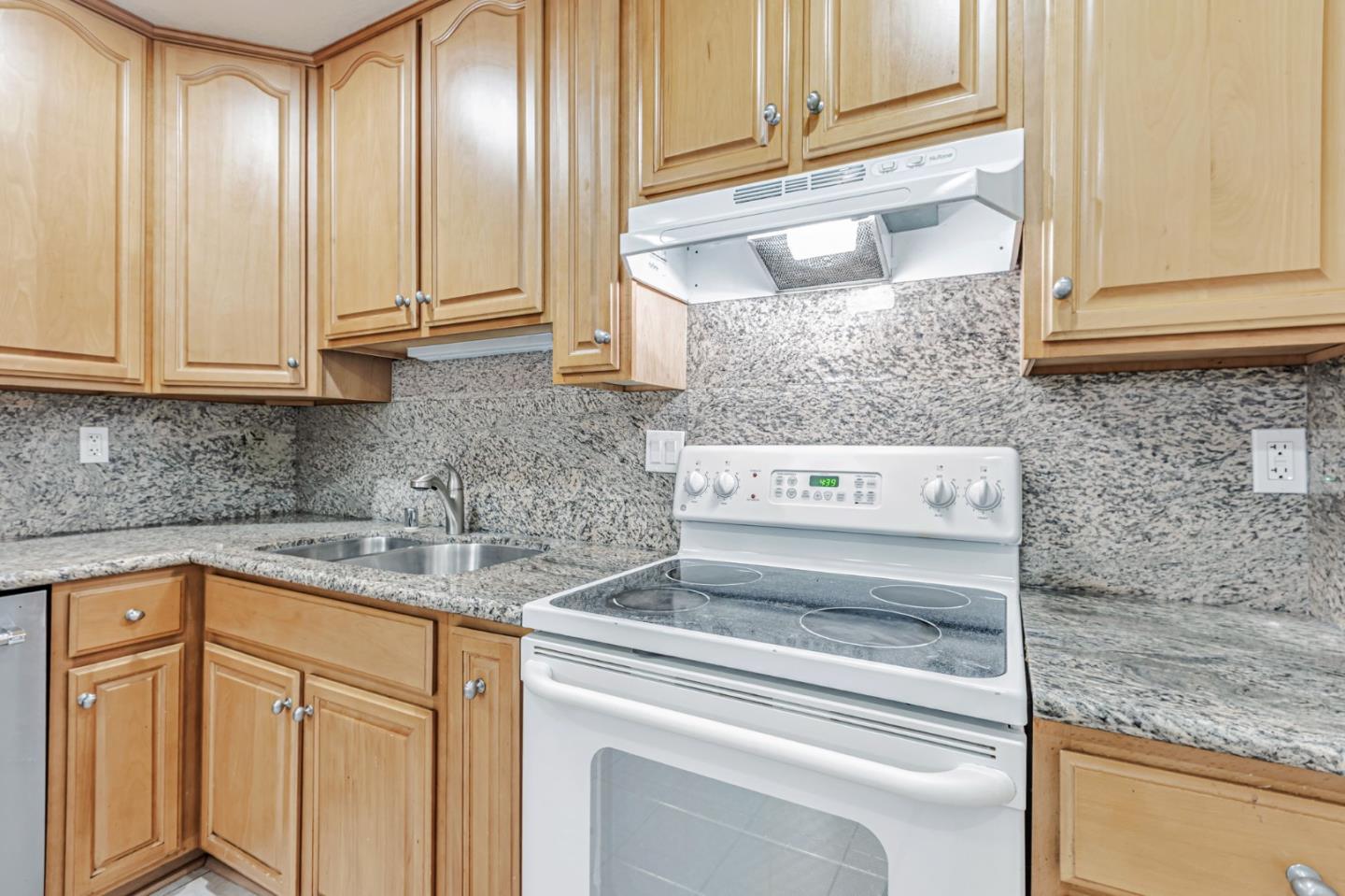 49 Showers Drive, Unit W203 Mountain View, CA 94040 - Photo 25 of 38 a kitchen with granite countertop cabinets and white appliances