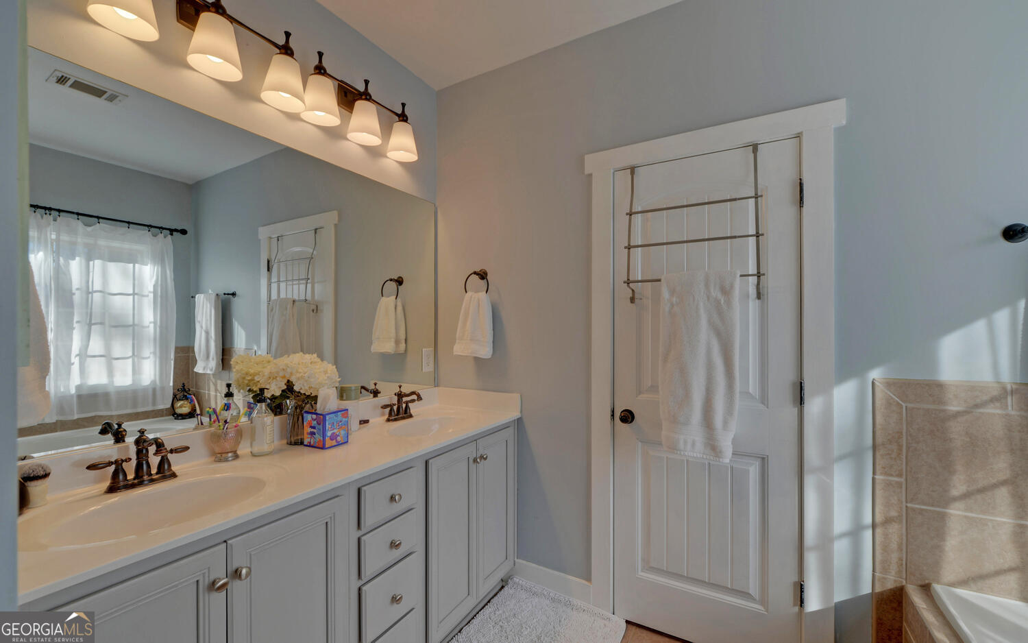 819 Tranquility Lane Hartwell, GA 30643 - Photo 16 of 81 a bathroom with a double vanity sink and a mirror