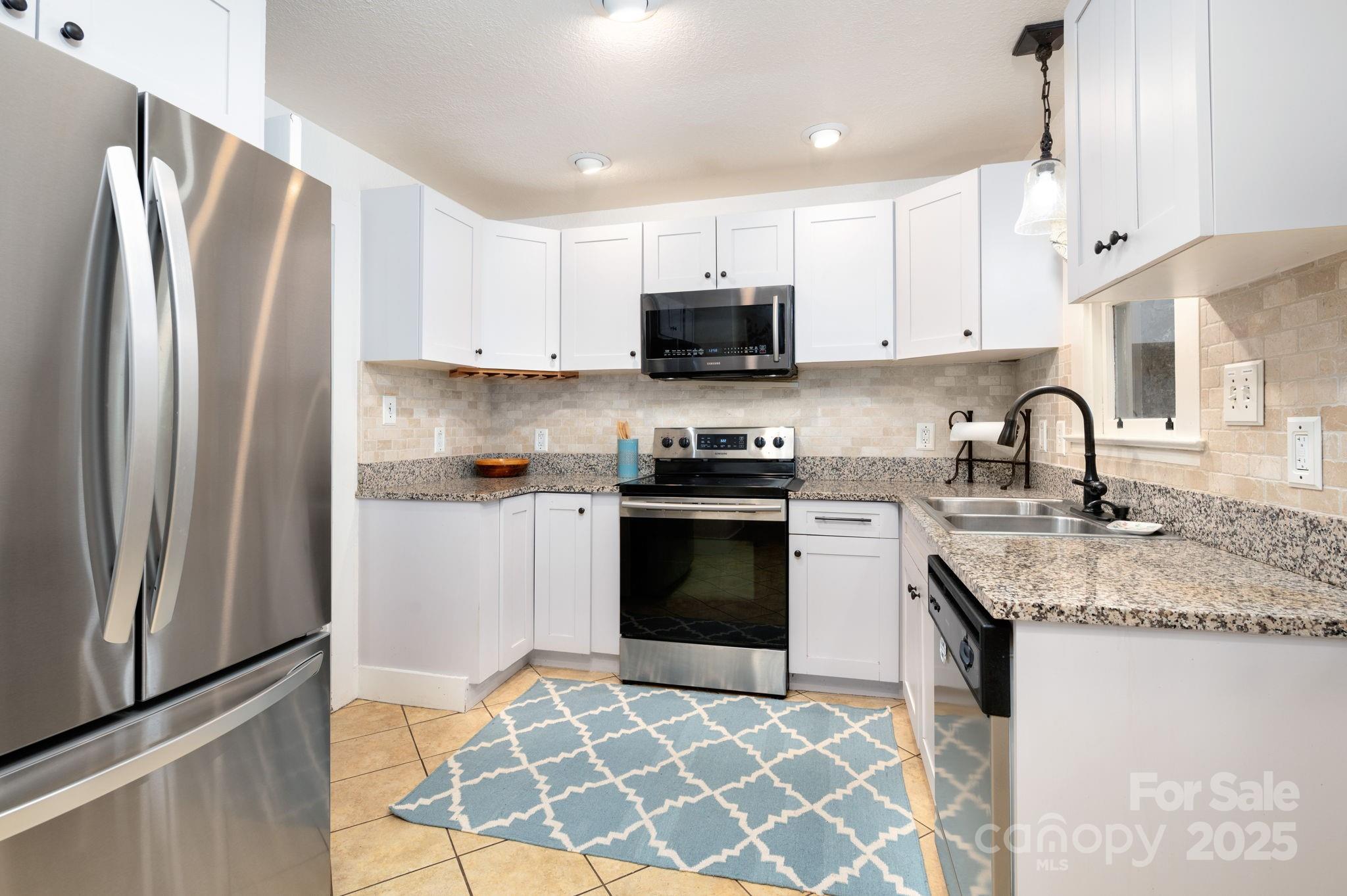 115 Oakland Road Asheville, NC 28801 - Photo 14 of 32 a kitchen with stainless steel appliances granite countertop a refrigerator sink and stove