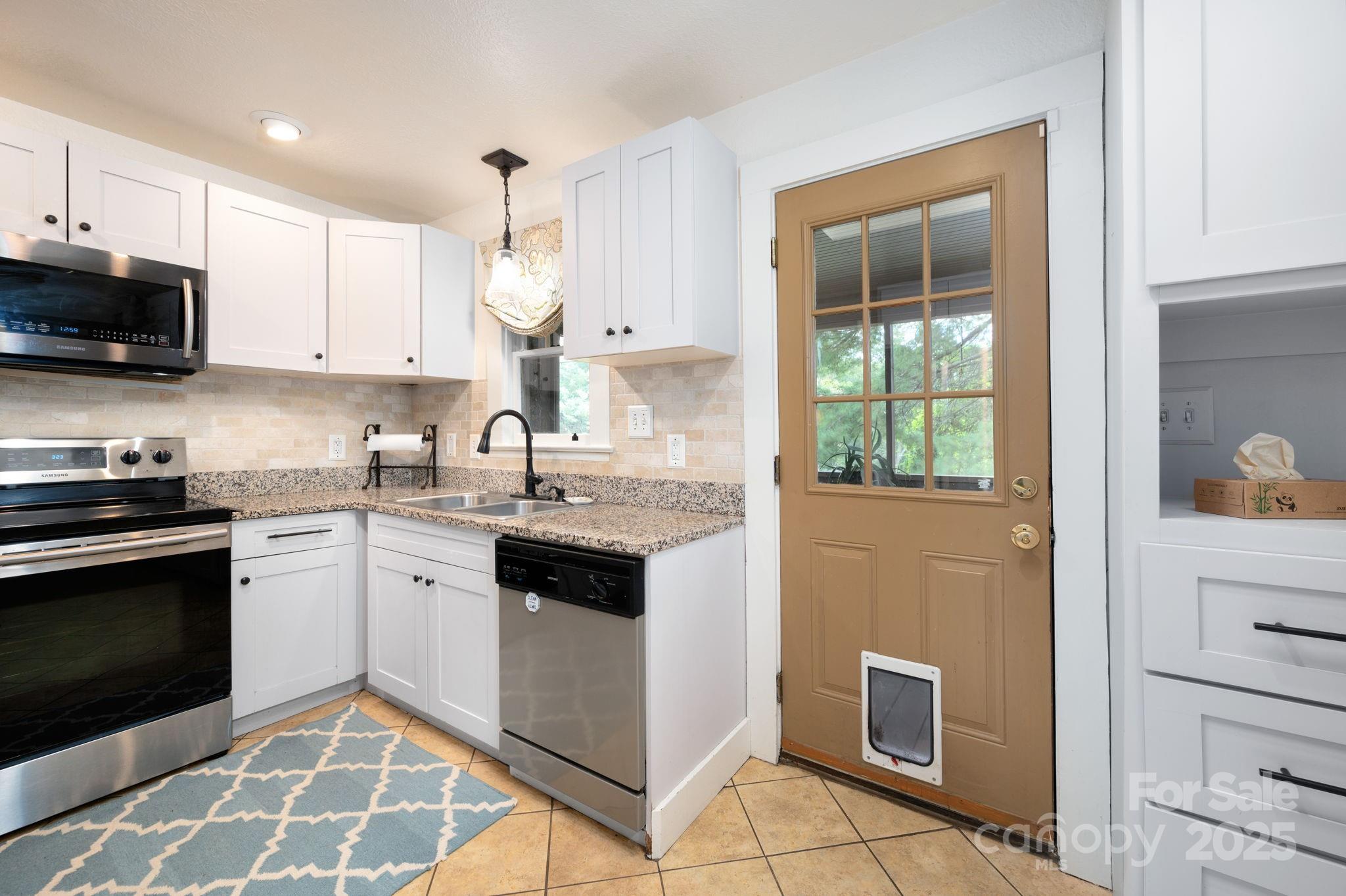 115 Oakland Road Asheville, NC 28801 - Photo 5 of 32 a kitchen with a stove sink and microwave