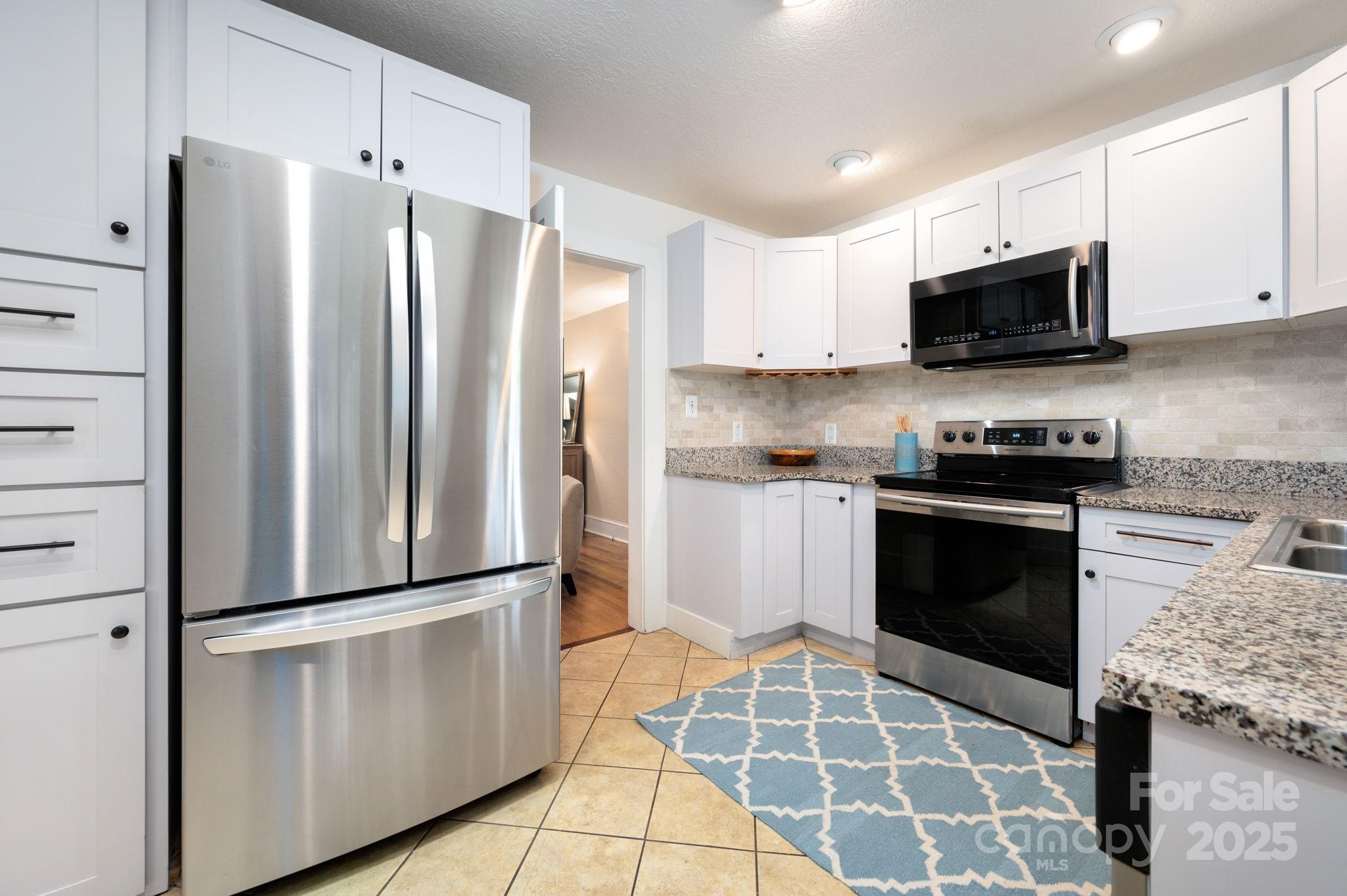 115 Oakland Road Asheville, NC 28801 - Photo 6 of 32 a kitchen with stainless steel appliances granite countertop a refrigerator stove and microwave