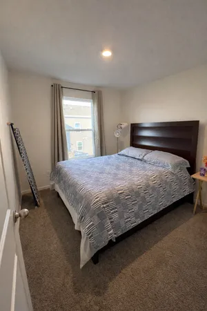 a bedroom with a bed next to a window