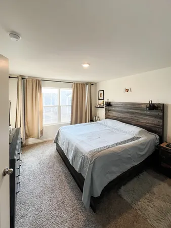 a spacious bedroom with a bed and a large window