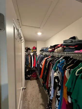 a view of walk in closet with clothes and shoes