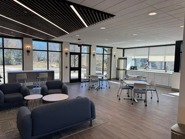 a living room with furniture wooden floor and a floor to ceiling window