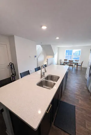 a kitchen with kitchen island a sink table and chairs