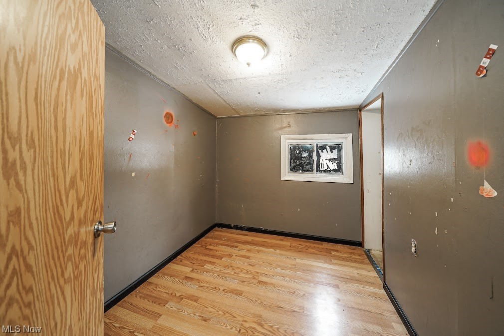 9606 Durst Colebrook Road North Bloomfield, OH 44450 - Photo 14 of 24 Spare room with light hardwood / wood-style flooring and a textured ceiling