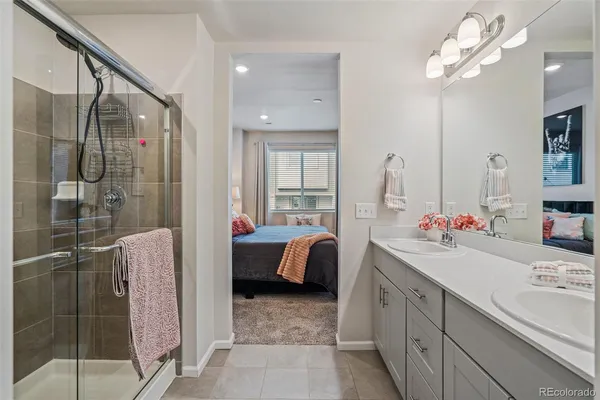 a bathroom with a double vanity sink mirror and shower