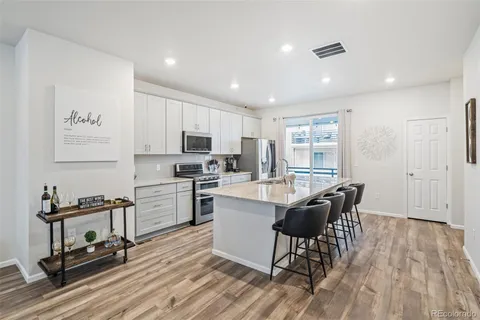 a kitchen with stainless steel appliances kitchen island granite countertop a stove a sink a refrigerator and cabinets