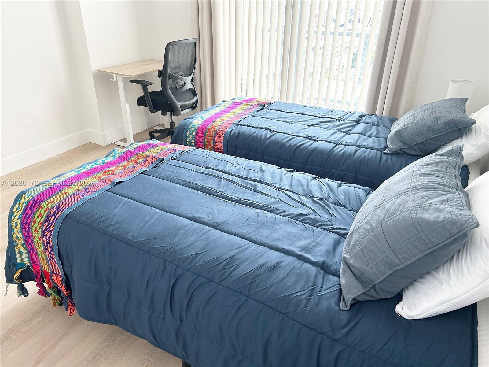 79 Southwest 12th Street, Unit 1710S Miami, FL 33130 - Photo 9 of 25 a bed sitting in a bedroom next to a window