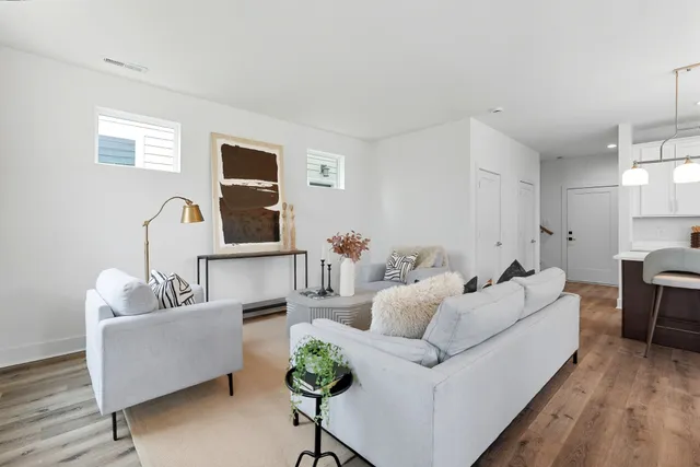 a living room with furniture and a wooden floor