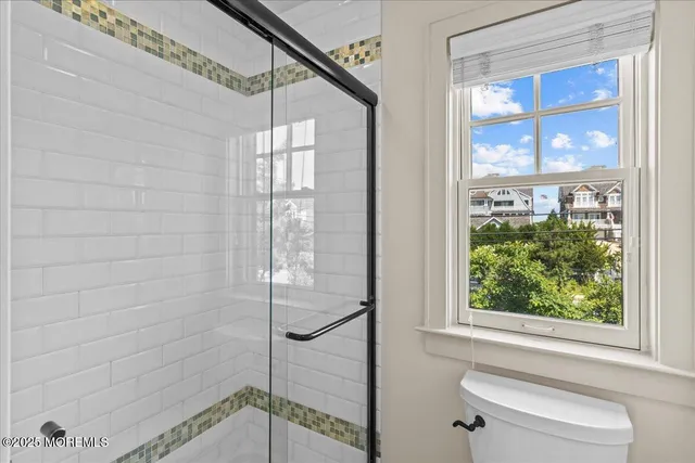 a bedroom with a large bed chandelier and a window