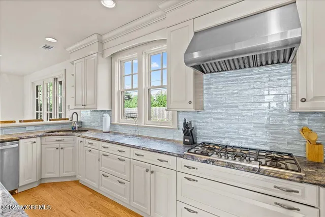 a kitchen with stainless steel appliances granite countertop a sink stove and refrigerator