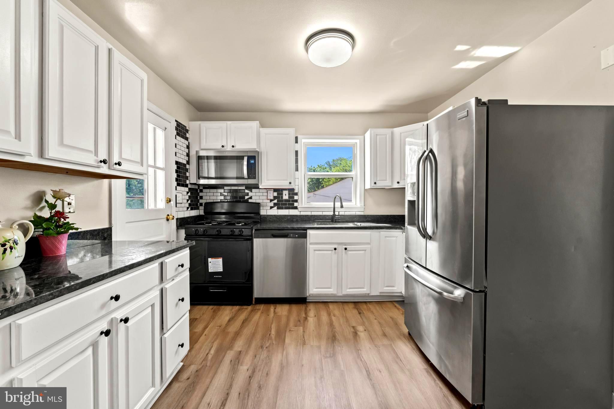 9307 Biltmore Drive Silver Spring, MD 20901 - Photo 7 of 33 a kitchen with stainless steel appliances a refrigerator sink and cabinets