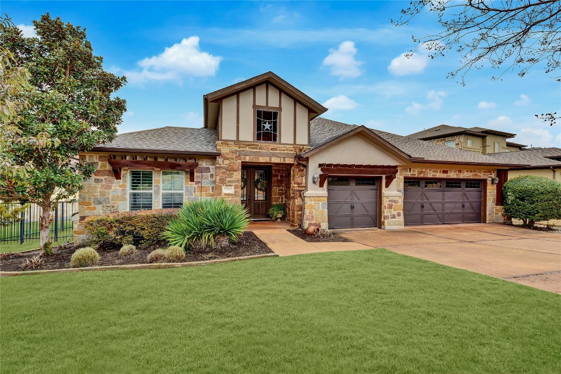 313 Enchanted Hilltop has a stone elevation with cedar accents and glass inset double entry doors.  Ease of parking with the flat driveway and side-by-side 3-car oversized garage with epoxy floors and EV charging!