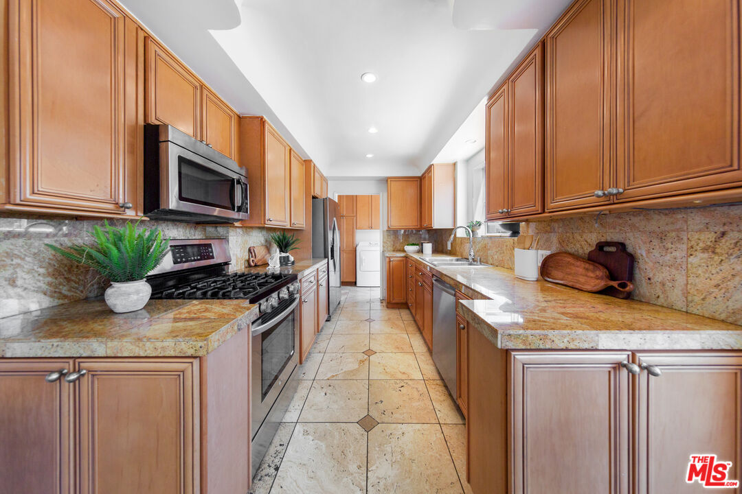 1904 Preuss Road Los Angeles, CA 90034 - Photo 8 of 32 a kitchen with stainless steel appliances granite countertop a sink stove and cabinets
