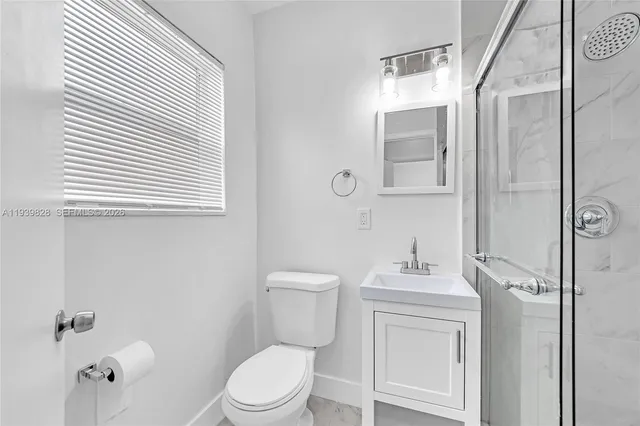 a bathroom with a toilet sink vanity and mirror