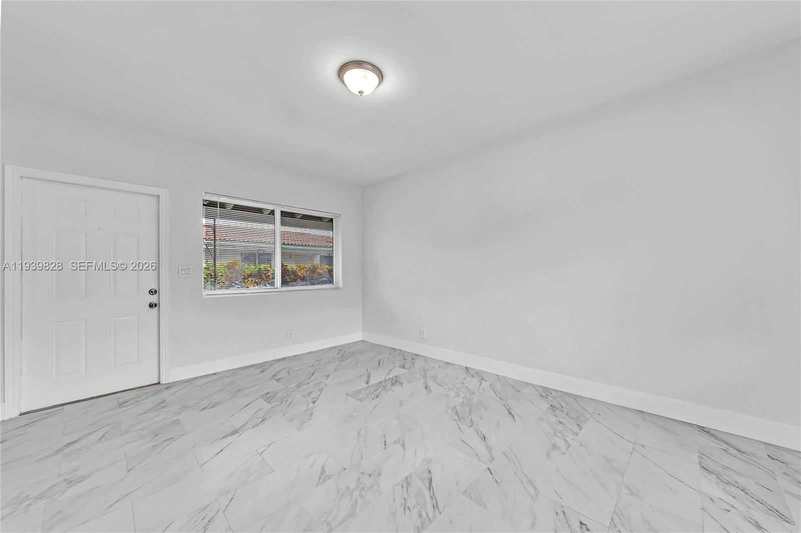 1839 Funston Street, Unit 2 Hollywood, FL 33020 - Photo 7 of 21 an empty room with wooden floor and windows