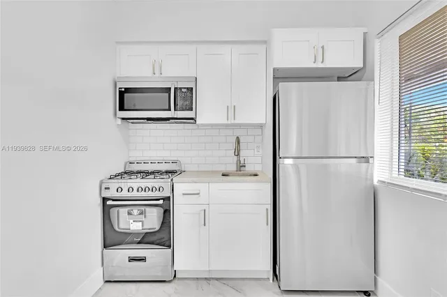 a kitchen with stainless steel appliances a stove microwave and refrigerator