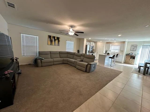 a living room with furniture a dining table and chairs with wooden floor