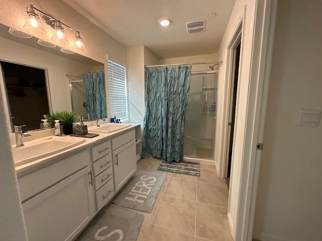 a bathroom with double vanity and a mirror