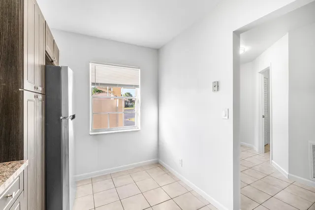 a view of an empty room with window and a bathroom